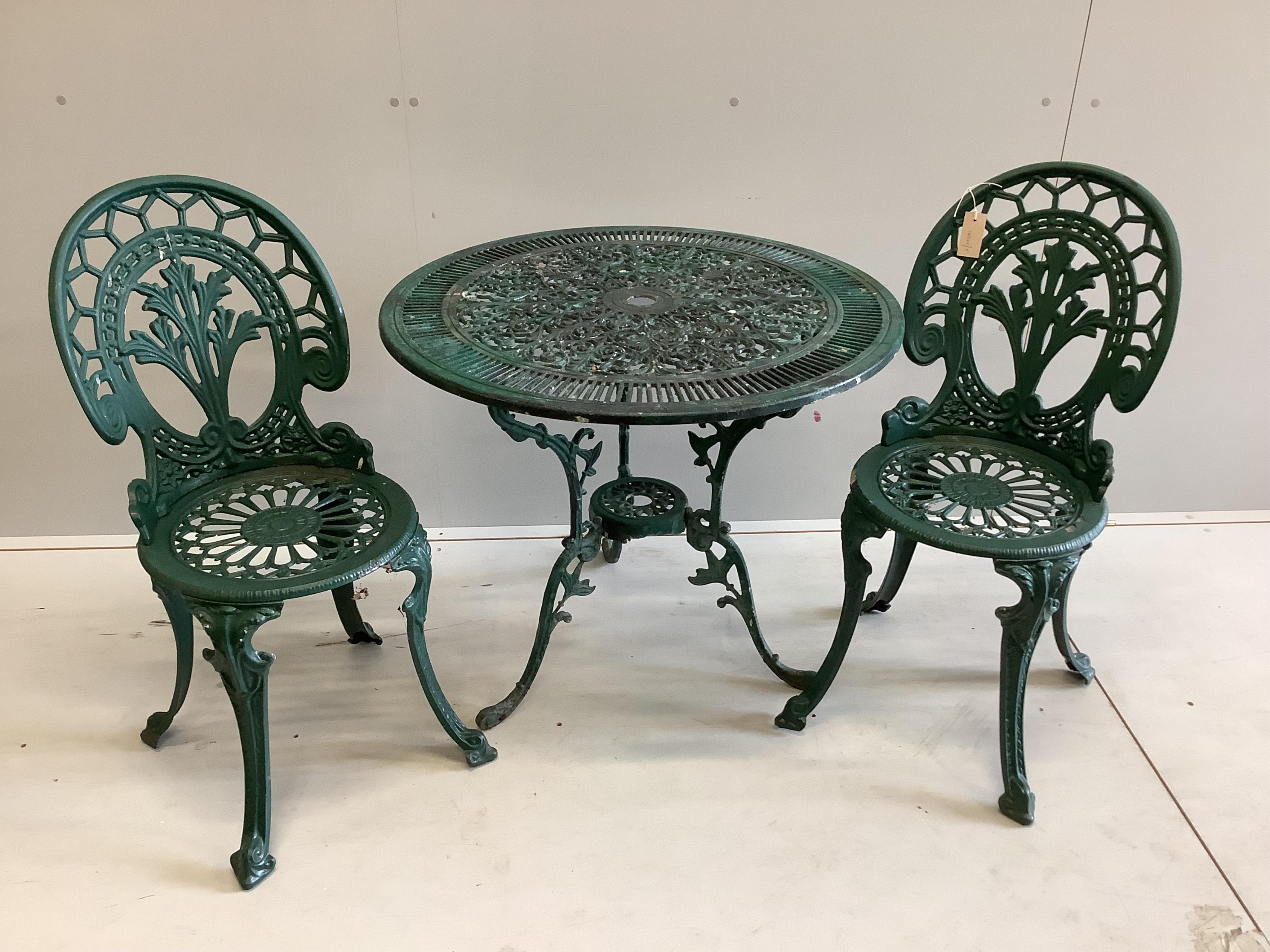 A Victorian style circular painted aluminium garden table, diameter 80cm, height 68cm, together with two chairs. Condition - fair